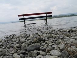 large pebbles and bench in the water of Lake Constance