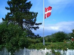 Danish flag on the flagpole behind the fence