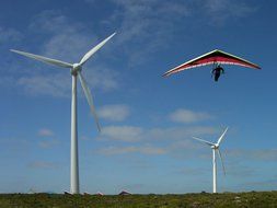 hang glider over wind turbines