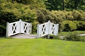 white bridge over the river in the park