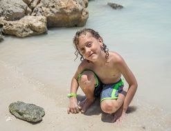 boy playing on the beach near the stones