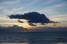 the departing sun behind the cloud
