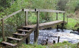 old wooden bridge above stream