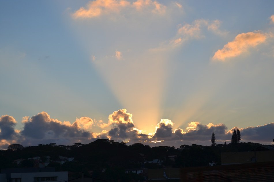 sunbeams behind white clouds