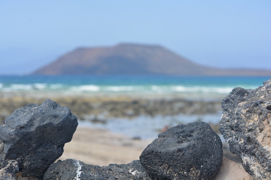 black stones in front of sea mountain