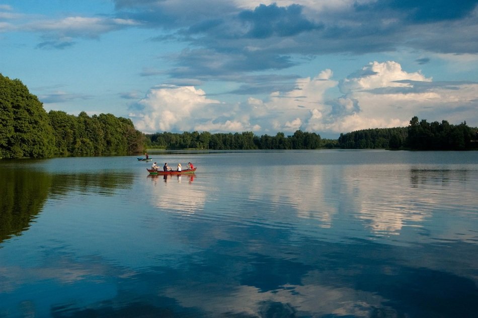 tourists on a boat in the middle of the lake in summer