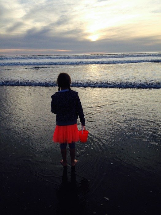 girl looks at the waves of the Pacific Ocean