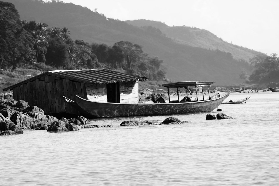 black and white photo of a hut and a fishing boat