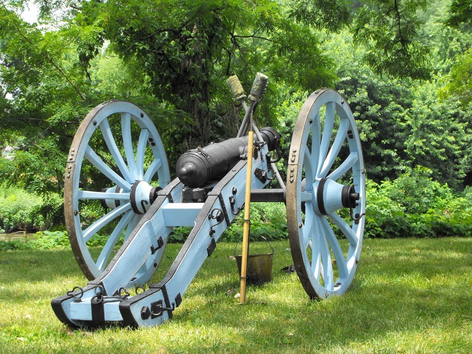 metal cannon on a green meadow