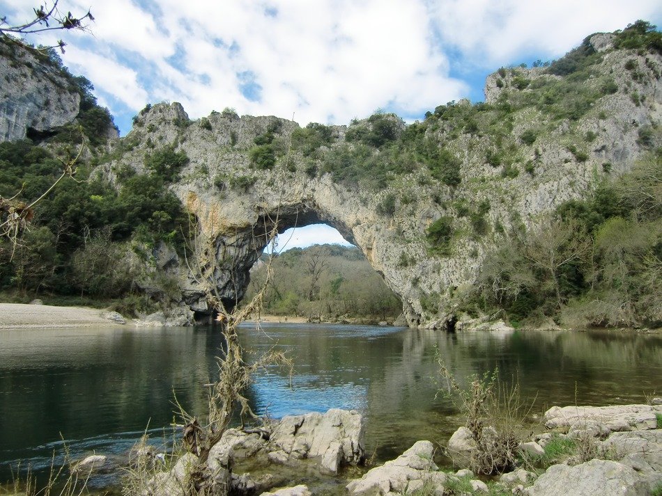 natural stone bridge with plants above the water in France