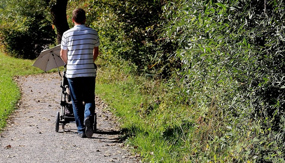 man walks with a stroller in the Park