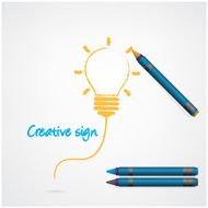 Colorful pencil crayons with creative light bulb sign on paper