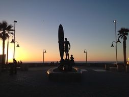 sculpture of a surfer on the waterfront in California