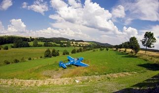 broken blue plane among picturesque scenery