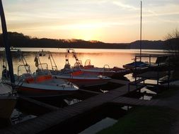 lifeboas moored near lake coast at sunset