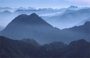 panoramic view of alpine mountains in haze