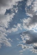 rays of the sun behind white clouds in the sky