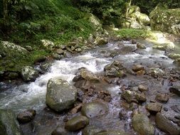 the stream flows over the rocks