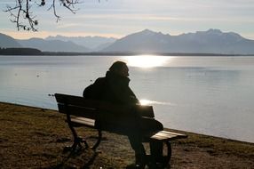 man resting on a bench by the lake