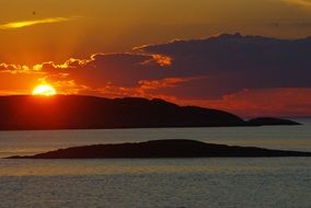 orange sunset over the mountain coast of the ocean