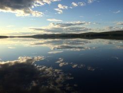 sky is reflected in the waters of the lake