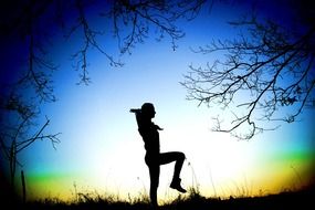 girl doing balancing exercise at sunset