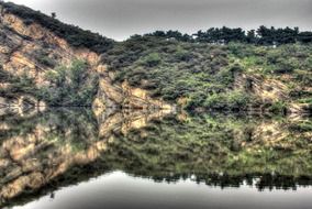 reflection of a green mountain in a lake