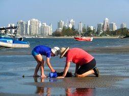 family plays with sand by the sea