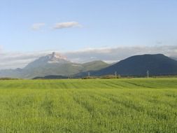 green field in front of scenic mountains, spain, santa cilia