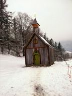 Small wooden chapel near the trees in beautiful winter, on beautiful landscape in Bavaria, Germany