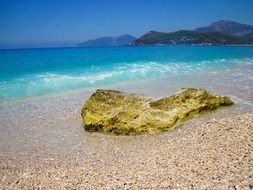 Rock on the beach in turquoise water