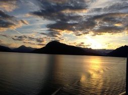 sunset over the mountains near a lake in alaska