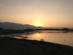 golden sunset on the background of the picturesque landscape of the lake and mountains