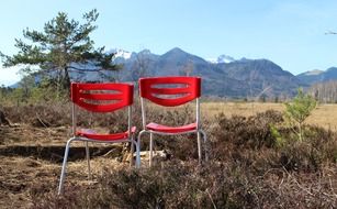 Red chairs in view of chiemgau mountains, germany