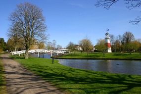 white wooden bridge across chanel in park at spring, denmark, kolding