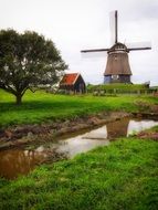 windmill near a creek in the netherlands