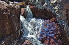 waterfall among colorful rocks