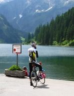 cyclists rests on lake shore, austria, tannheim