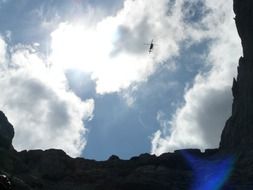 helicopter high in the mountains against a cloudy sky