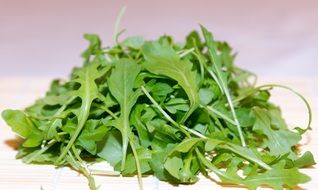 green leaves of arugula on a white surface