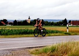 man on road bike in country landscape, germany, erbach