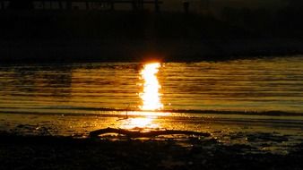 reflection of the bright sun in the water at sunset