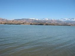 lake at the foot of a mountain with snow