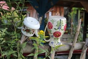 ceramic jug and teapot on the fence