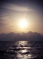 sunset over mountains over water