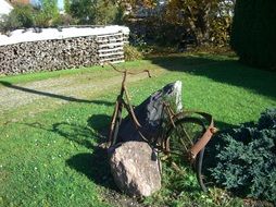 Rusty bike and rocks on the green field