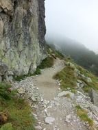 The path on the foggy rock cliff