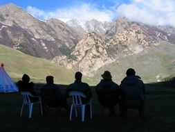 Sitting people are watching beautiful landscape with mountains