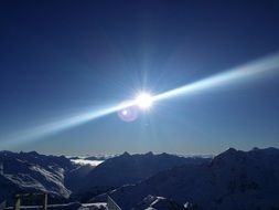 glare of the sun over the alpine mountain