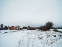 freight train rides along a winter field in Poland